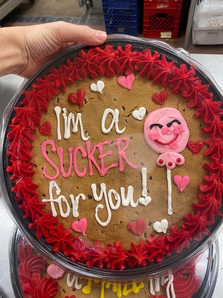 Vibrant Cookie Cake with Heart Shapes and Playful Character for Festive Celebrations.