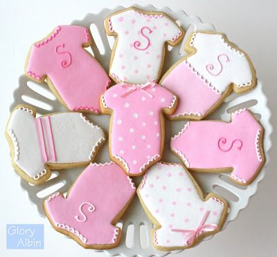 Whimsical Baby Onesie-Shaped Cookies in Elegant Pink and White for Celebrations.