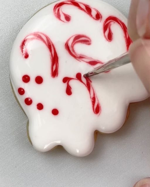 Festive Treat-Inspired Nail Art: Glossy White Base with Playful Red Patterns for a Cheerful Holiday Look.