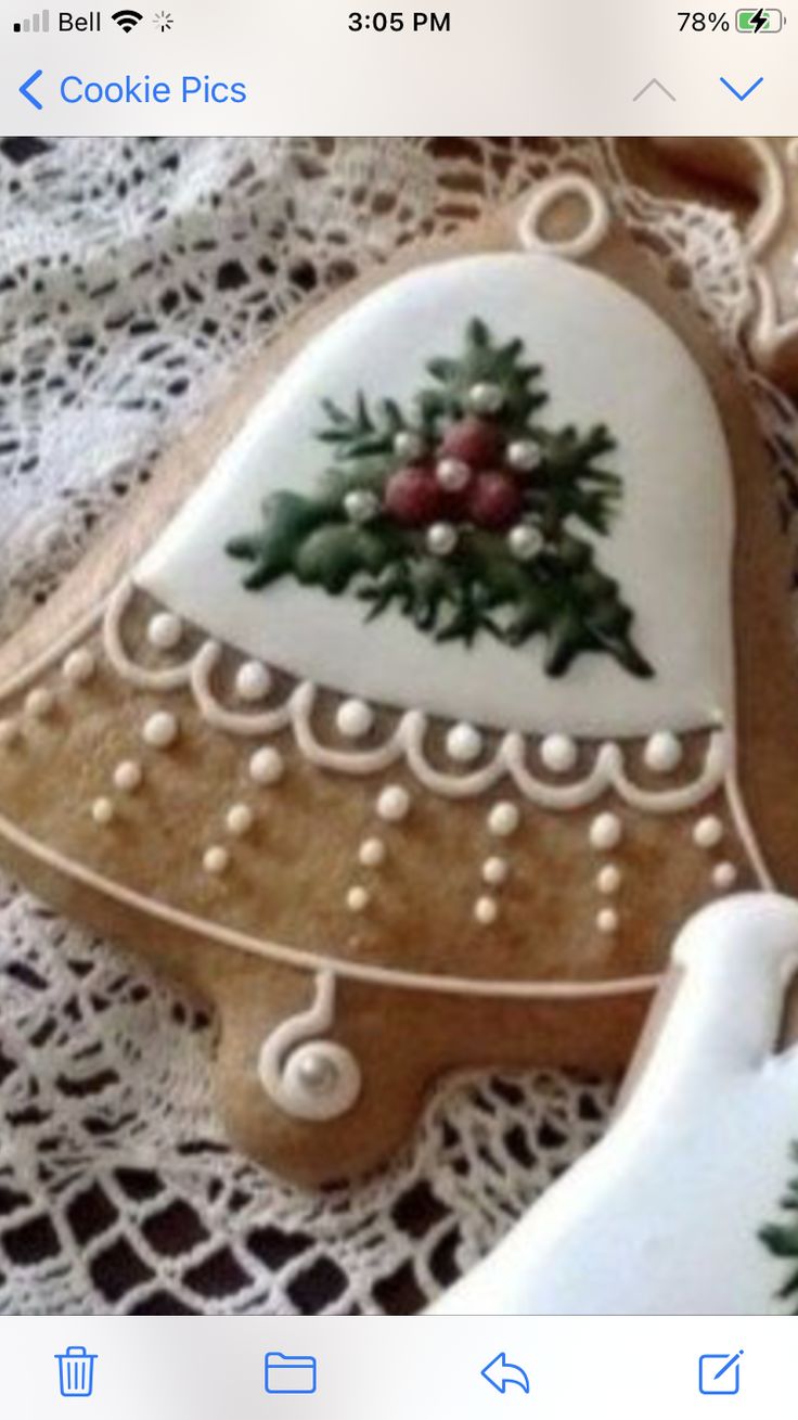 Elegant Holiday Bell Cookie Design with Green Foliage and Red Berries.