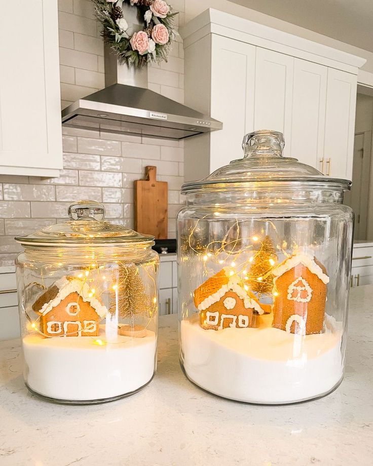 Enchanting Gingerbread House Display in Glass Jars with Twinkling Lights and Whimsical Snow Landscape.