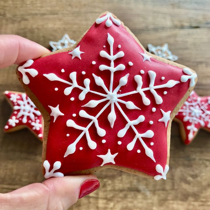 Cheerful Festive Star-Shaped Cookies with Red Icing and White Snowflake Designs.