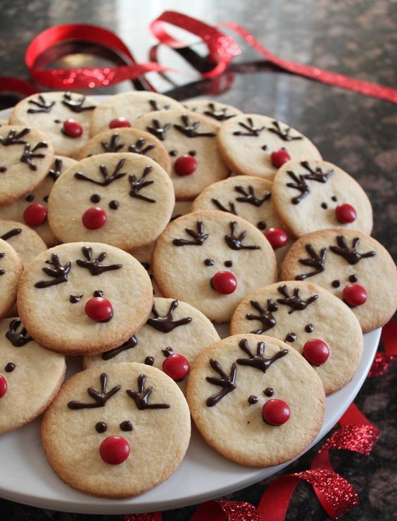 Cheerful Festive Reindeer Cookies Adorned with Chocolate Antlers and Red Noses in a Shimmering Display.