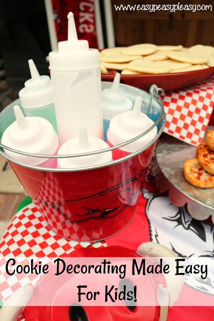 Colorful Frosting Bottles and Checkered Tablecloth Inspire Creative Cookie Decorating for Kids.