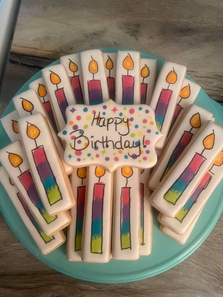 Vibrant Birthday Cookies with Artistic Candle Designs on a Cheerful Turquoise Plate.