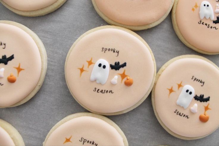 Charming Pastel Halloween Cookies with Playful Designs on Textured Surface