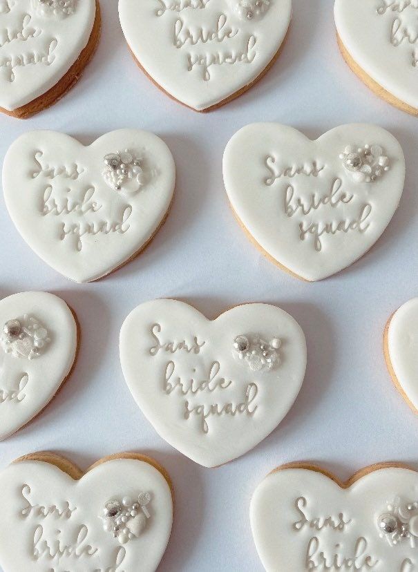 Elegant Heart-Shaped Bridal Cookies with Smooth Icing and Charming Script.