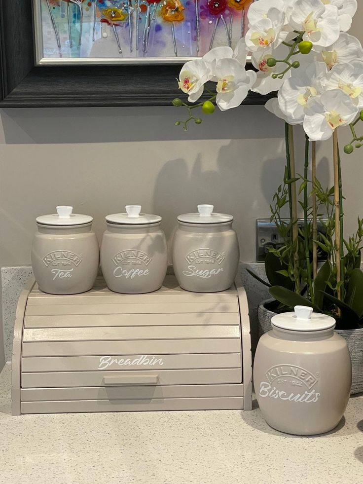 Elegant Kitchen Countertop Arrangement with Cream Canisters and Artistic Touches