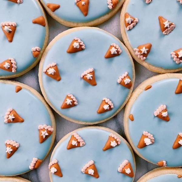 Whimsical Decorative Cookies with Soft Blue Icing and Miniature Ice Cream Cones for Celebrations.