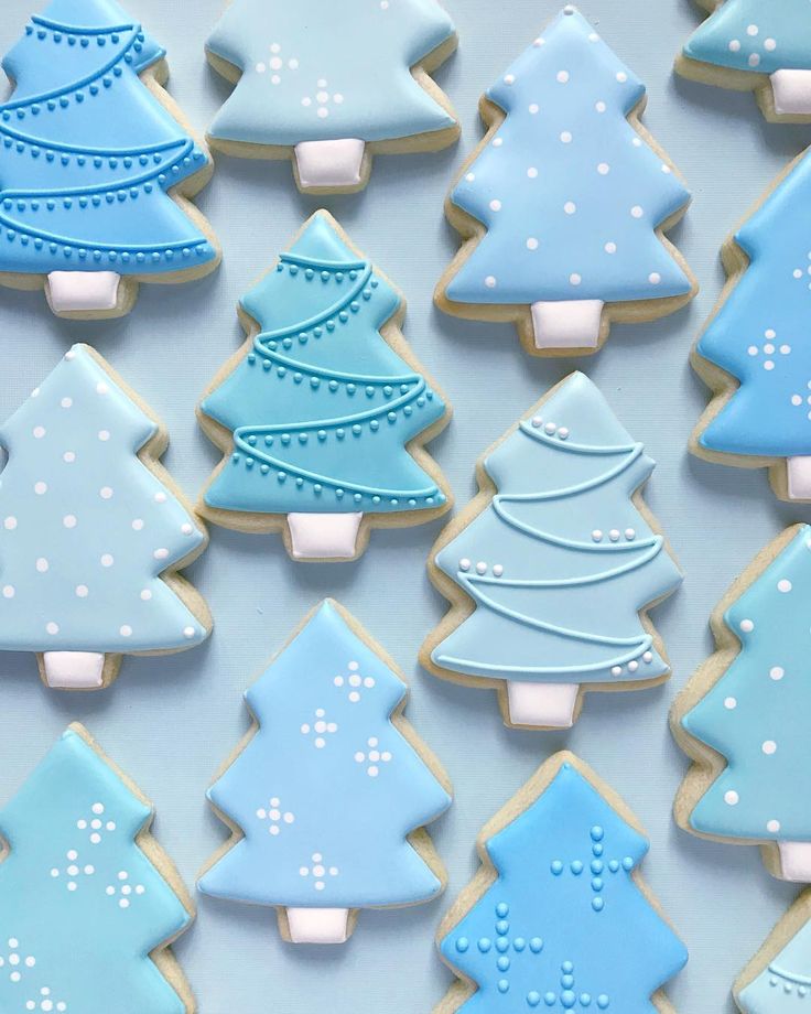 Festive Blue Christmas Tree Cookies with Intricate Icing Designs.